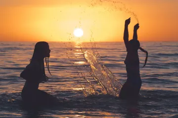 Siesta Beach: Two Girls Splash in the Water at Sunset